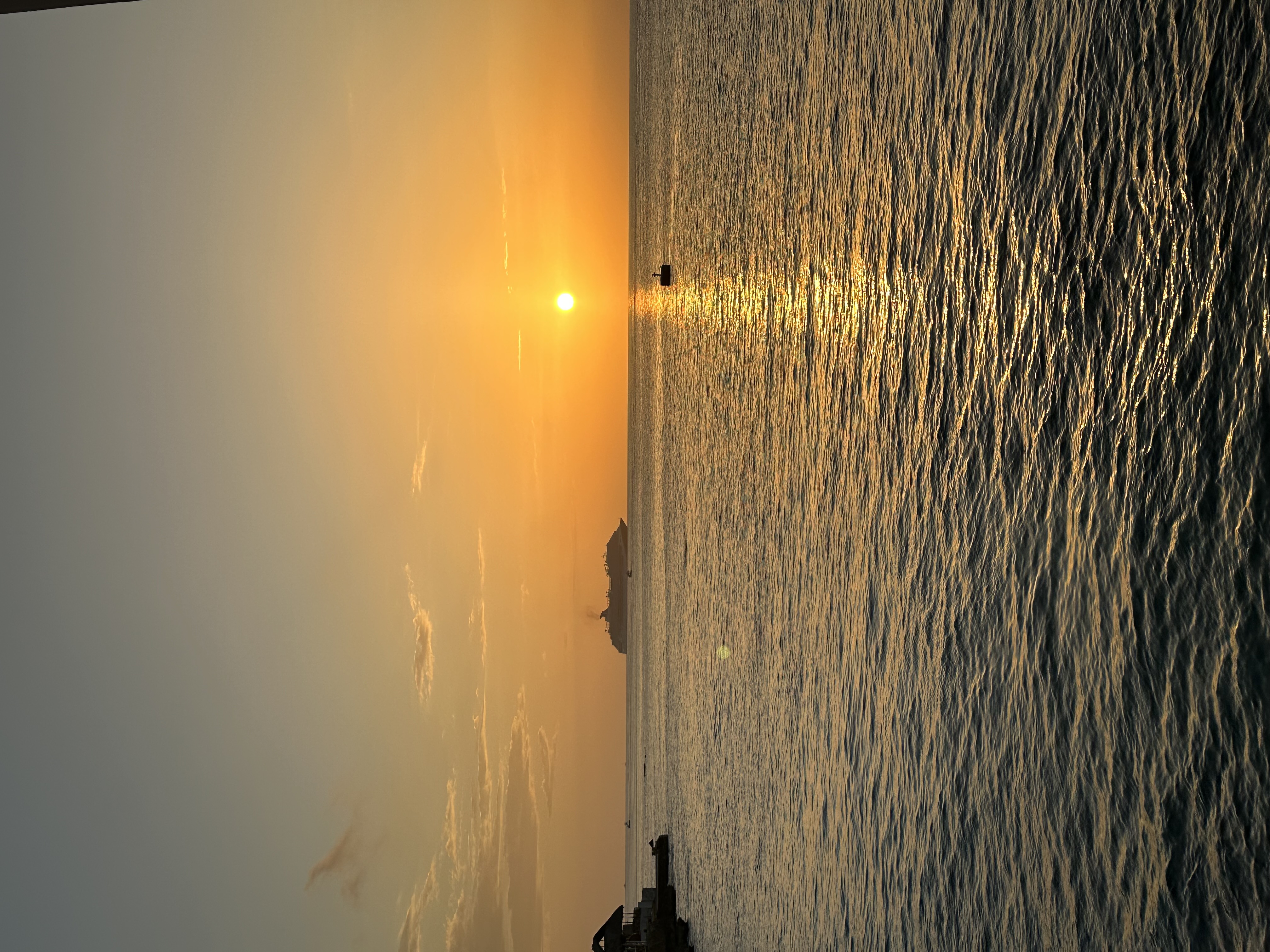 Sunset over water with a cruise ship